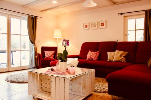 ein Wohnzimmer mit einem roten Sofa und einem Tisch in der Unterkunft Zum Alten Backhaus in Burg