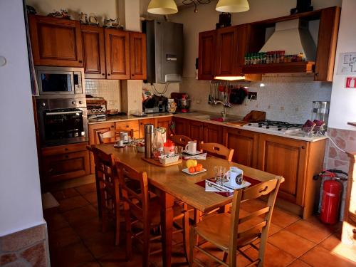a kitchen with a wooden table and wooden chairs at Vecchia Roma Resort in Rome