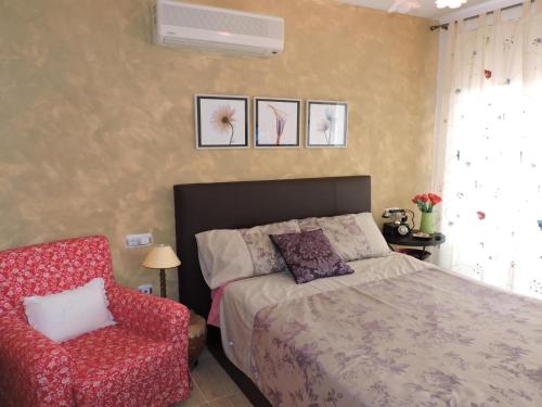 um quarto com uma cama e uma cadeira vermelha em Doree 503 em Miami Platja