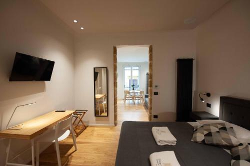 a bedroom with a bed and a table and a desk at Palazzo al Carmine in Monreale