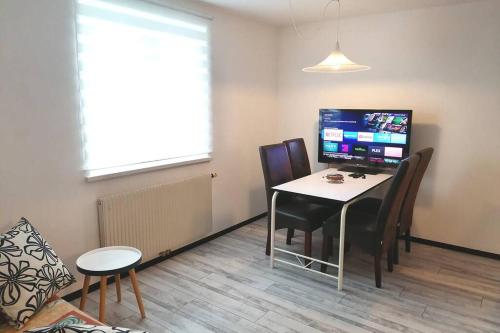 Cette chambre dispose d'une table avec des chaises et d'un ordinateur. dans l'établissement Dimai House No 17 Dornbirn Zentrum, à Dornbirn
