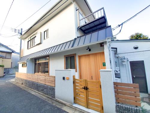 a white house with a fence and a balcony at Haku Wakanayanagi Inn in Kyoto