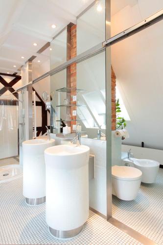 a bathroom with three sinks and two toilets at Mühle am Schlossberg in Wartenberg-Rohrbach