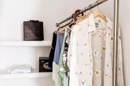 a group of clothes hanging on a rack in a closet at Charisma Suites in Oia