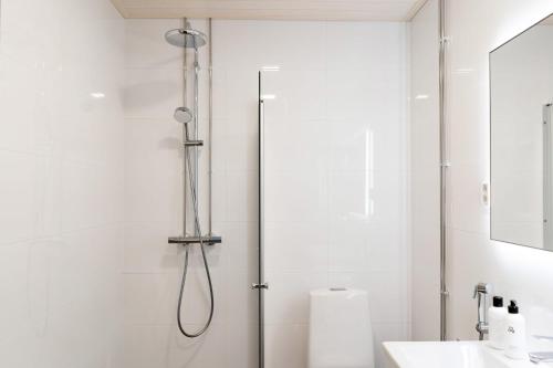 a shower in a bathroom with a glass door at Roost Hämeenkatu in Tampella