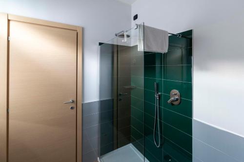 a bathroom with a shower with green tiles at Il giardino di Fiorina in Novate Milanese