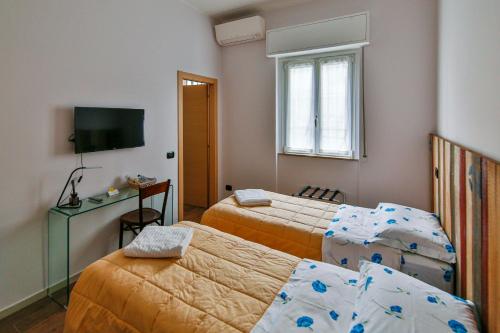 a hotel room with two beds and a television at Il giardino di Fiorina in Novate Milanese