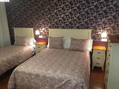 1 Schlafzimmer mit 2 Betten und einer Tapete in der Unterkunft Hostal El Puerto Boutique in Chipiona