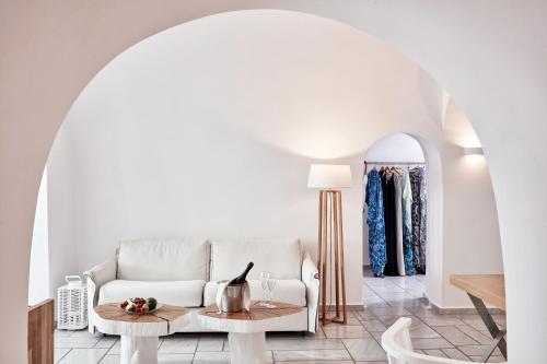 a living room with a white couch and a table at Charisma Suites in Oia