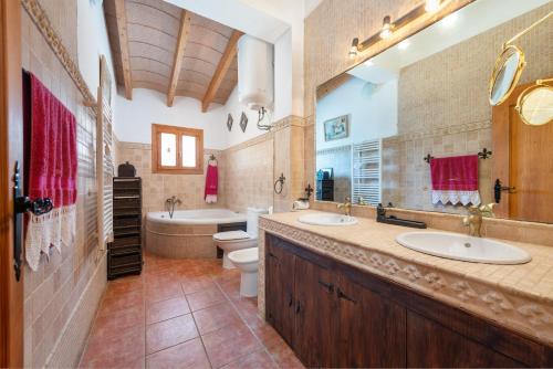 y baño con 2 lavabos, bañera y aseo. en Cas Mostatxet (Sencelles), en Sencelles