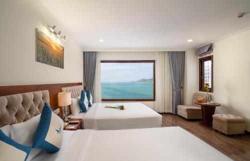 a hotel room with two beds and a window at Apus Hotel in Nha Trang