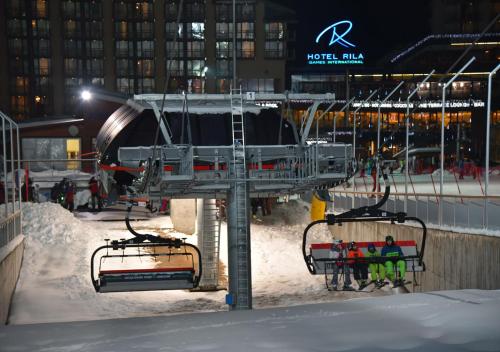 a ski lift with people on it in the snow at Rila Hotel Borovets in Borovets