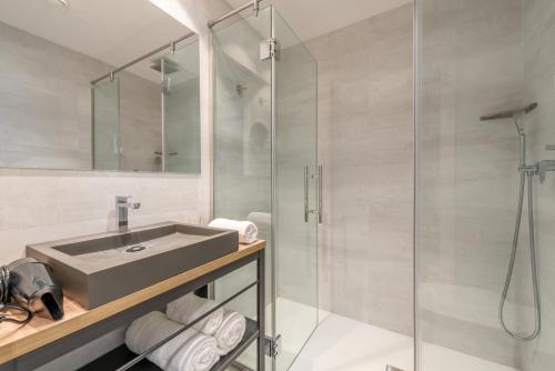 a bathroom with a sink and a shower at Kyrat Amarac Suites in Cala Millor
