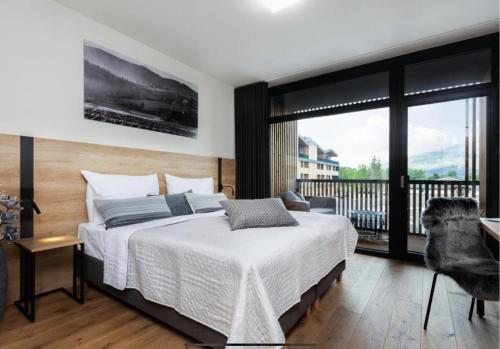 a bedroom with a bed and a balcony at Golf House Čeladná in Čeladná