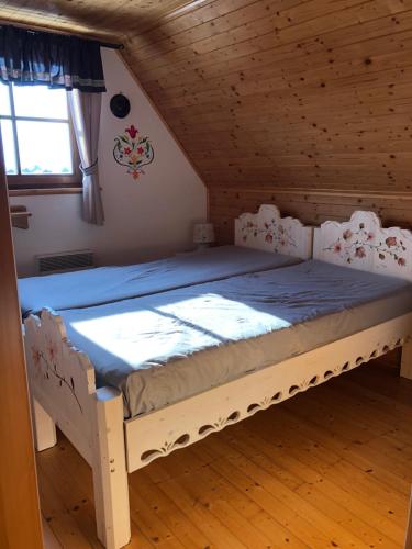 a bedroom with a bed in a wooden room at Chatka Katka in Liptovský Mikuláš