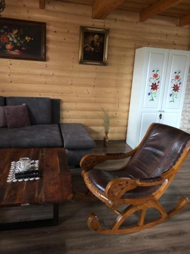 a living room with a leather chair and a couch at Chatka Katka in Liptovský Mikuláš