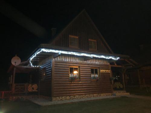 a house with lights on the side of it at night at Chatka Katka in Liptovský Mikuláš