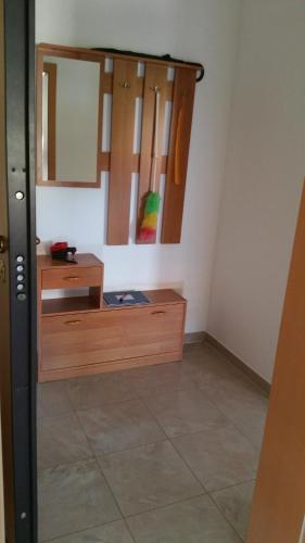 Cette chambre comprend un bureau et un miroir mural. dans l'établissement Apartman Dana, à Premantura