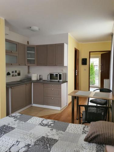 a kitchen with brown cabinets and a table with a microwave at siodemkacamp in Łeba