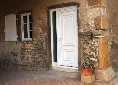 a white door with a potted plant in front of a building at LeDeN in Lissieu