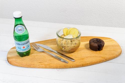 a bottle of beer and a dessert and a drink on a cutting board at Comfort Aparthotel Bordeaux Begles Arena in Bègles