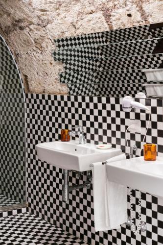 a bathroom with two sinks and a checkered wall at Marina Piccola 73 in Sorrento