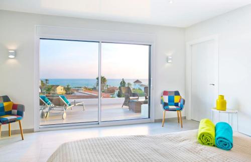 een slaapkamer met een grote glazen deur met uitzicht op de oceaan bij Extravagant 8 BDRM Villa In Marbella, Beachside in Marbella