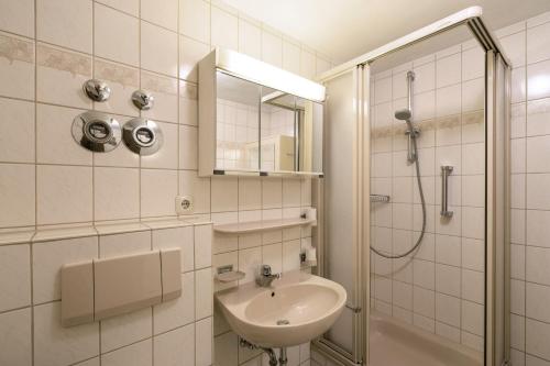 a white bathroom with a sink and a shower at Ferienwohnungen Wolter in Oberstdorf