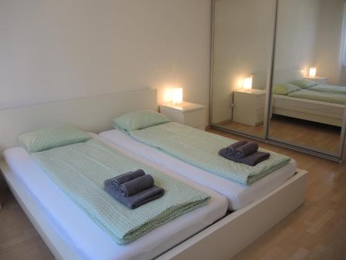 2 Betten in einem Zimmer mit Spiegel in der Unterkunft Ullmann in Ascona