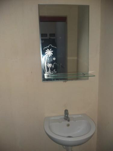 a bathroom with a sink and a mirror at Nadyah Syariah Homestay in Ketapang