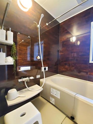 a bathroom with a tub and a toilet and a sink at Haku Wakanayanagi Inn in Kyoto