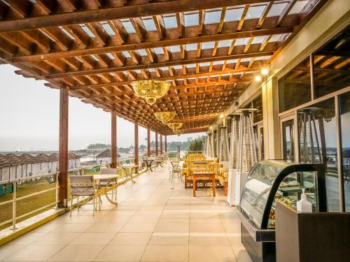 a restaurant with tables and chairs on a balcony at Al Kout Beach Hotel in Kuwait