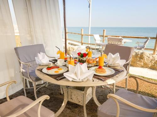 a table with food on it with the ocean in the background at Al Kout Beach Hotel in Kuwait
