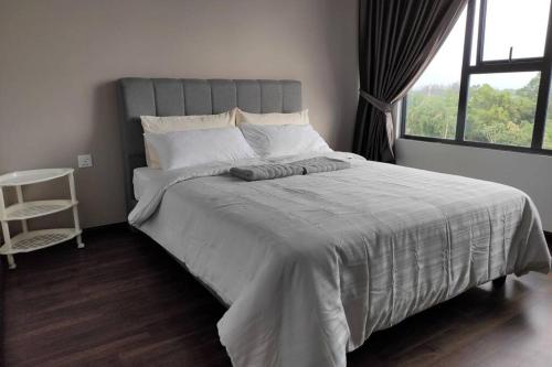 a bedroom with a large bed with a large window at Cozzyhome@REX BDC in Kuching