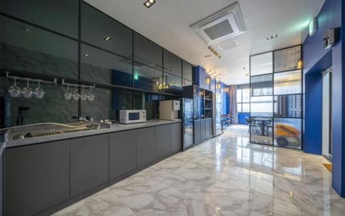 duża kuchnia z niebieskimi szafkami i blatem w obiekcie St. 179 Incheon Hotel w mieście Inczon