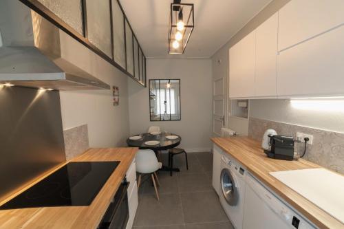 cocina con lavadora, secadora y mesa en PRESTIGELOC Appart 3 Chambres 2 SDB La Loire en Orléans