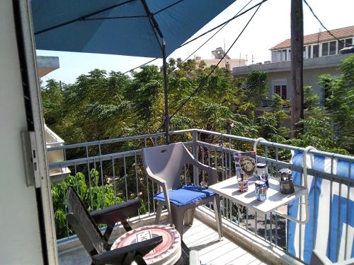 a table and chairs on a balcony with an umbrella at Apollon Apartments H-3 H-4 in Rhodes Town