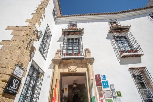 a large building with a clock on the side of it at Hotel Soho Boutique Palacio San Gabriel in Ronda
