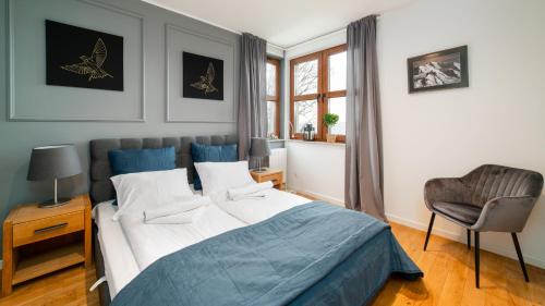 1 dormitorio con 1 cama, 1 silla y 1 ventana en Apartamenty Sun & Snow Residence Karpacz en Karpacz