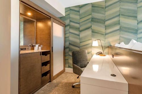 a bathroom with a desk and a chair in a room at Cambria Hotel Ocean City - Bayfront in Ocean City