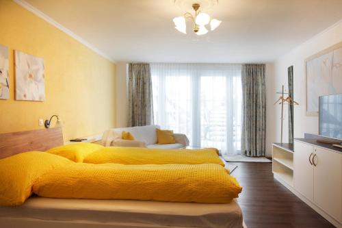 ein Schlafzimmer mit einem gelben Bett mit einer gelben Decke in der Unterkunft B&B Siglistorf in Siglistorf