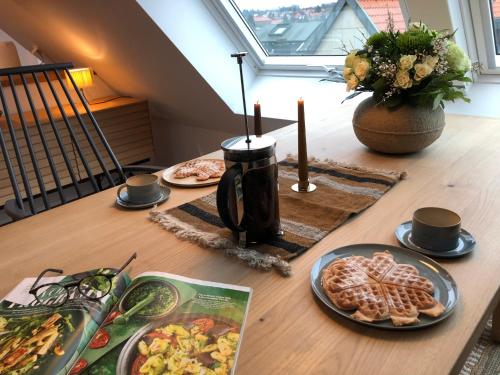 a wooden table with plates of food on it at RaumAusbeute Design Apartment Hoher Priester in Detmold
