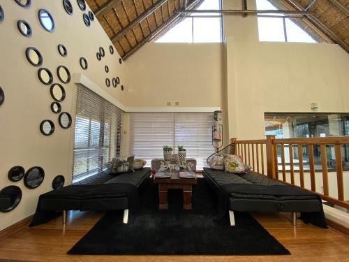 a living room with two couches and a table at Vaal River YOLO Spaces - Vaal River Bush Villa in Sasolburg