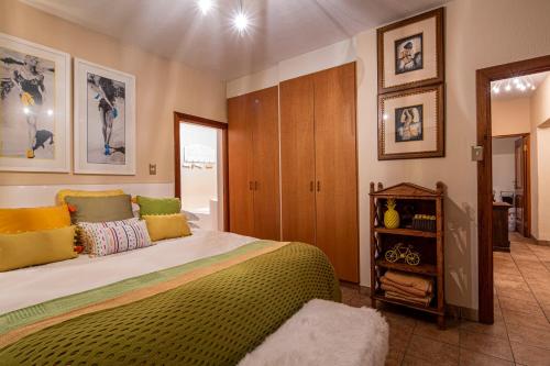 a bedroom with a large bed with colorful pillows at Vaal River YOLO Spaces - Vaal River Bush Villa in Sasolburg