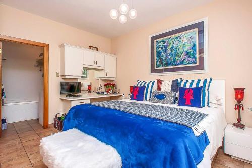 a bedroom with a blue bed and a kitchen at Vaal River YOLO Spaces - Vaal River Bush Villa in Sasolburg