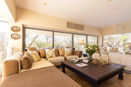 a living room with two couches and a coffee table at Vaal River YOLO Spaces - Vaal River Bush Villa in Sasolburg