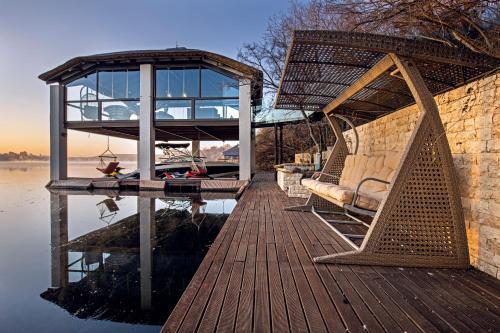 a wooden dock with a house on the water at Vaal River YOLO Spaces - Vaal River Bush Villa in Sasolburg