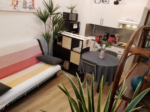 a room with a table and a couch and a table with flowers at Wonderful heart of Nice, AC, 15" sea in Nice