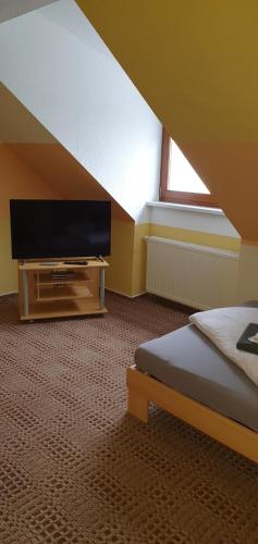 a bedroom with a flat screen tv and a bed at Landpension Wendfeld in Sanitz