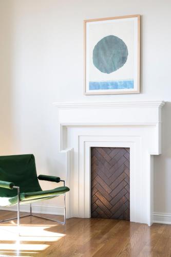 a living room with a green chair and a fireplace at Kimpton Cottonwood Hotel by IHG in Omaha
